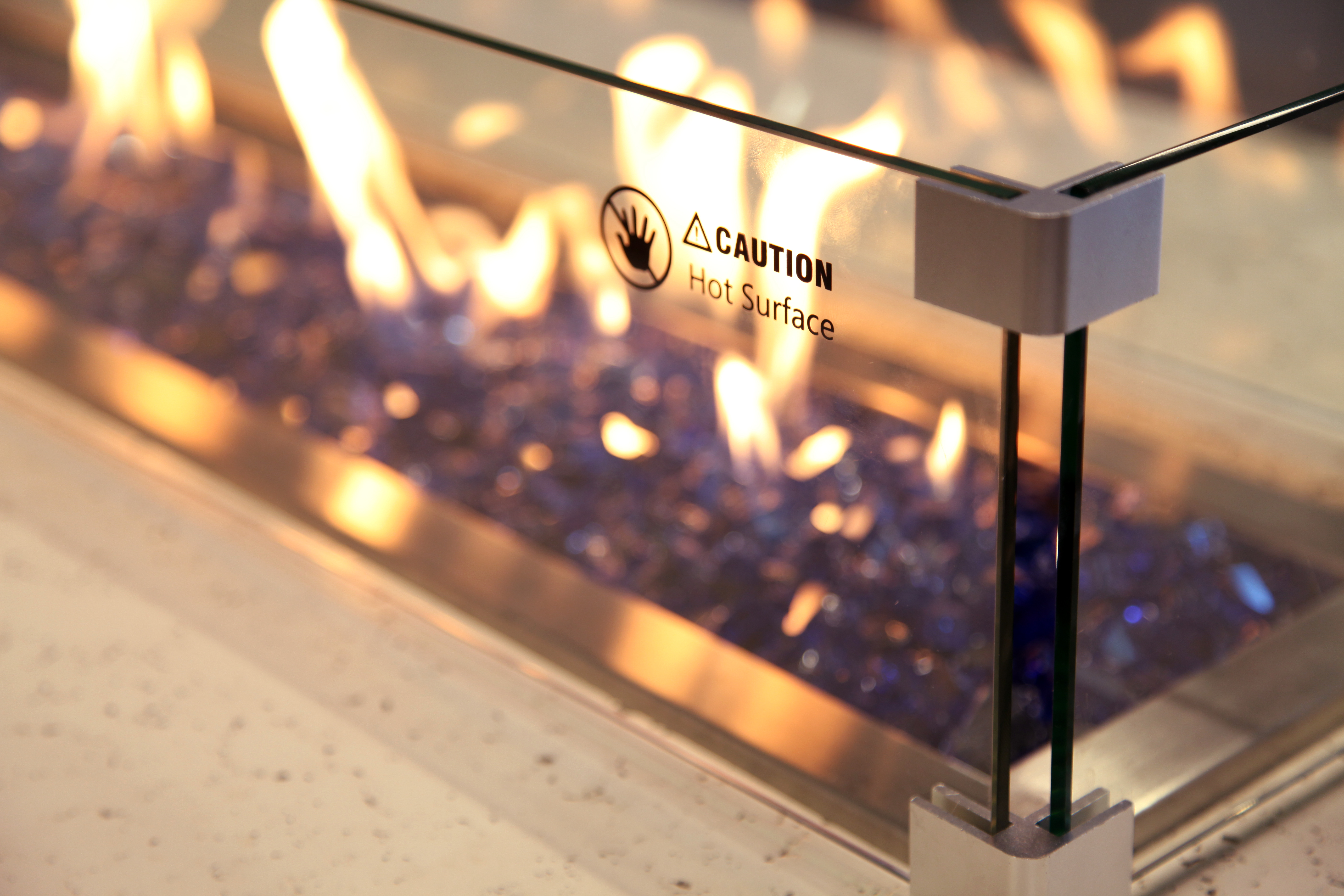 Outdoor fire table with glass wind guard